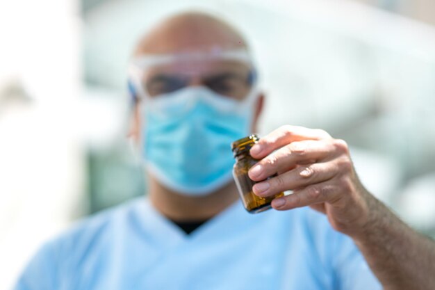doctor wearing lab coat surgical mask safety goggles offering bottle liquid antibiotics 1048944 17157828 - Marxx Pharma Private Limited